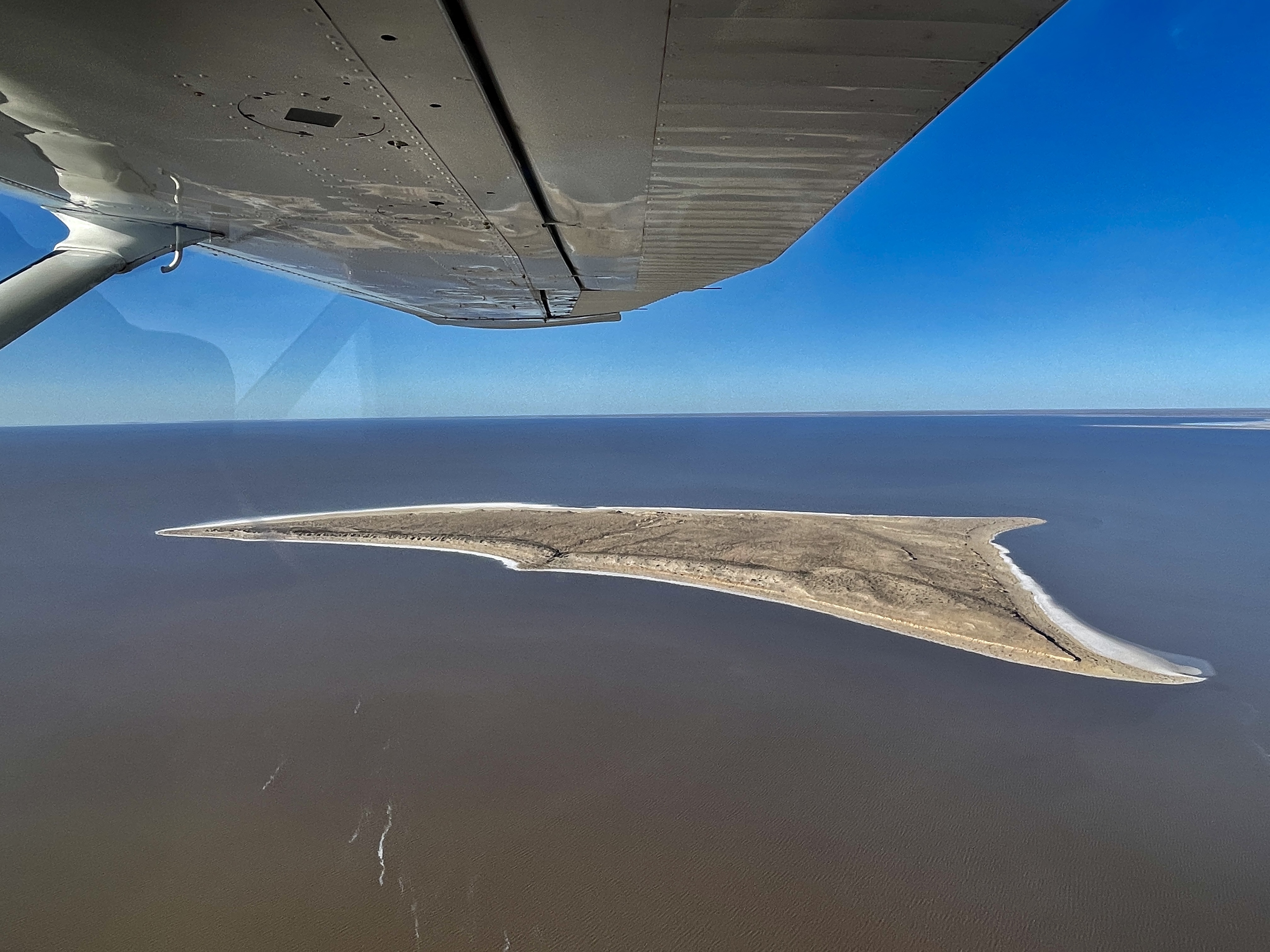 Sandy island in Lake Eyre beneath the wing of a scenic flight