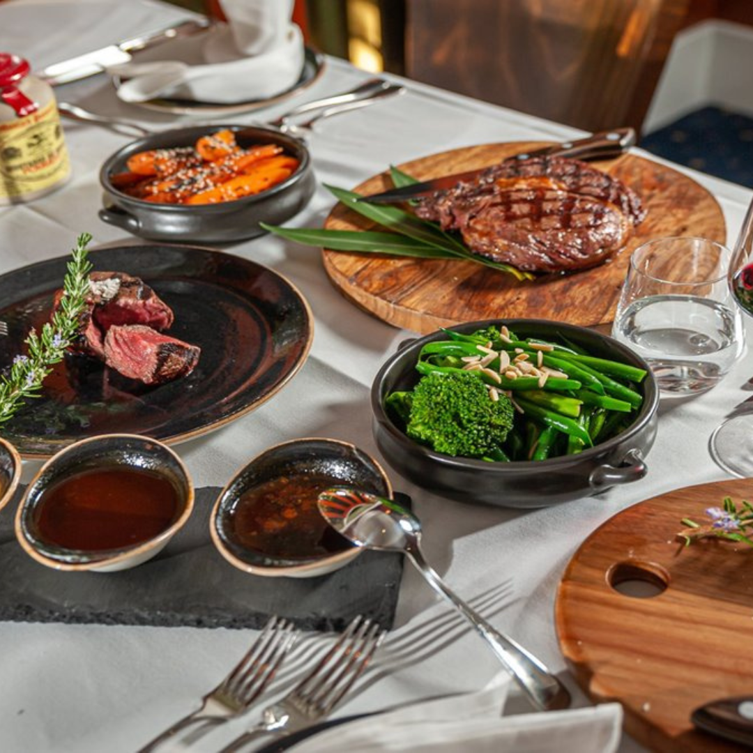 Restaurant dinner of steak, greens and sides