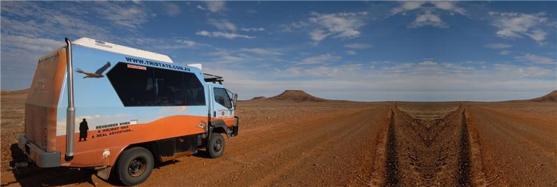Overland Adventures expedition truck parked on a red dirt road