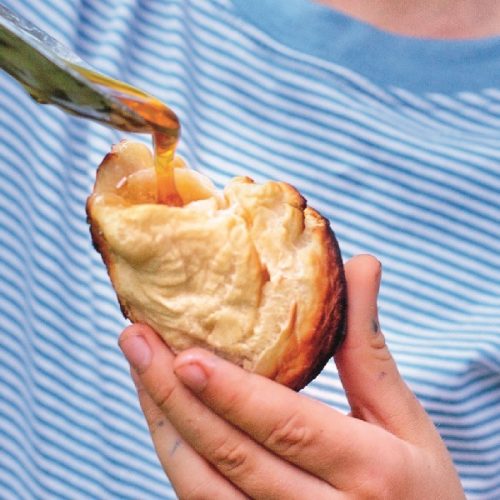 Hand holding a freshly baked campfire bread roll