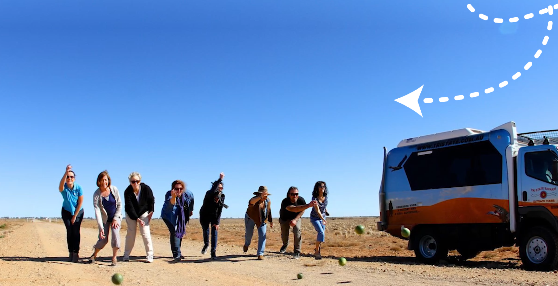 Tour guests lined up beside the Overland Adventures truck on the open plains