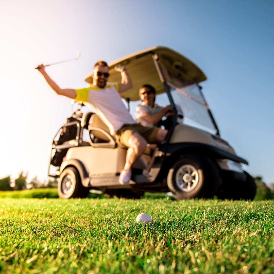 Two golfers in a golf cart on a sunny fairway