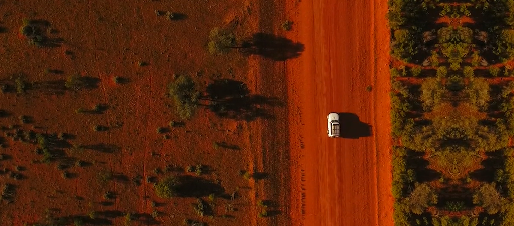 Aerial view of a vehicle on a red outback road
