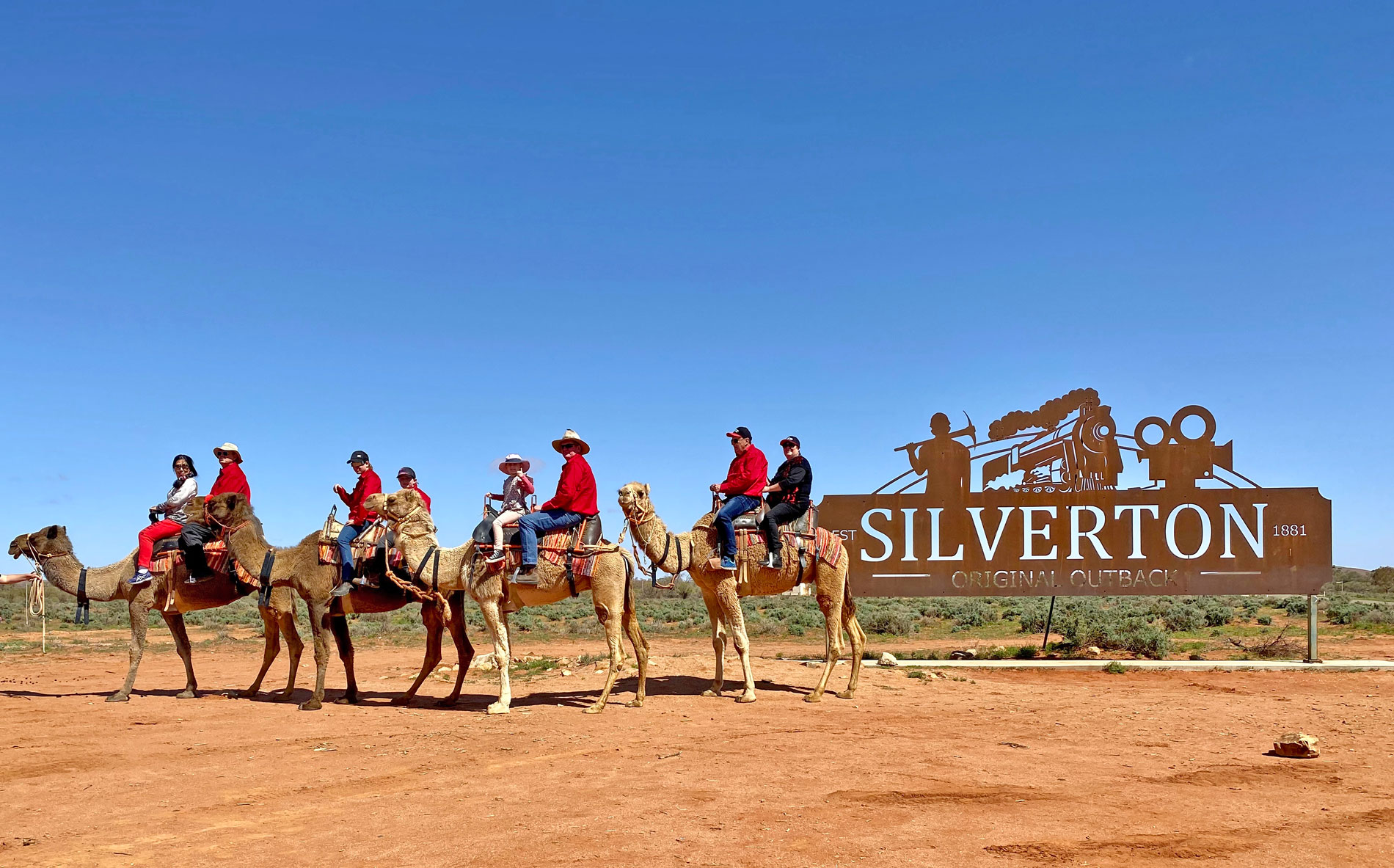 Camel riders lined up beside the Silverton sign