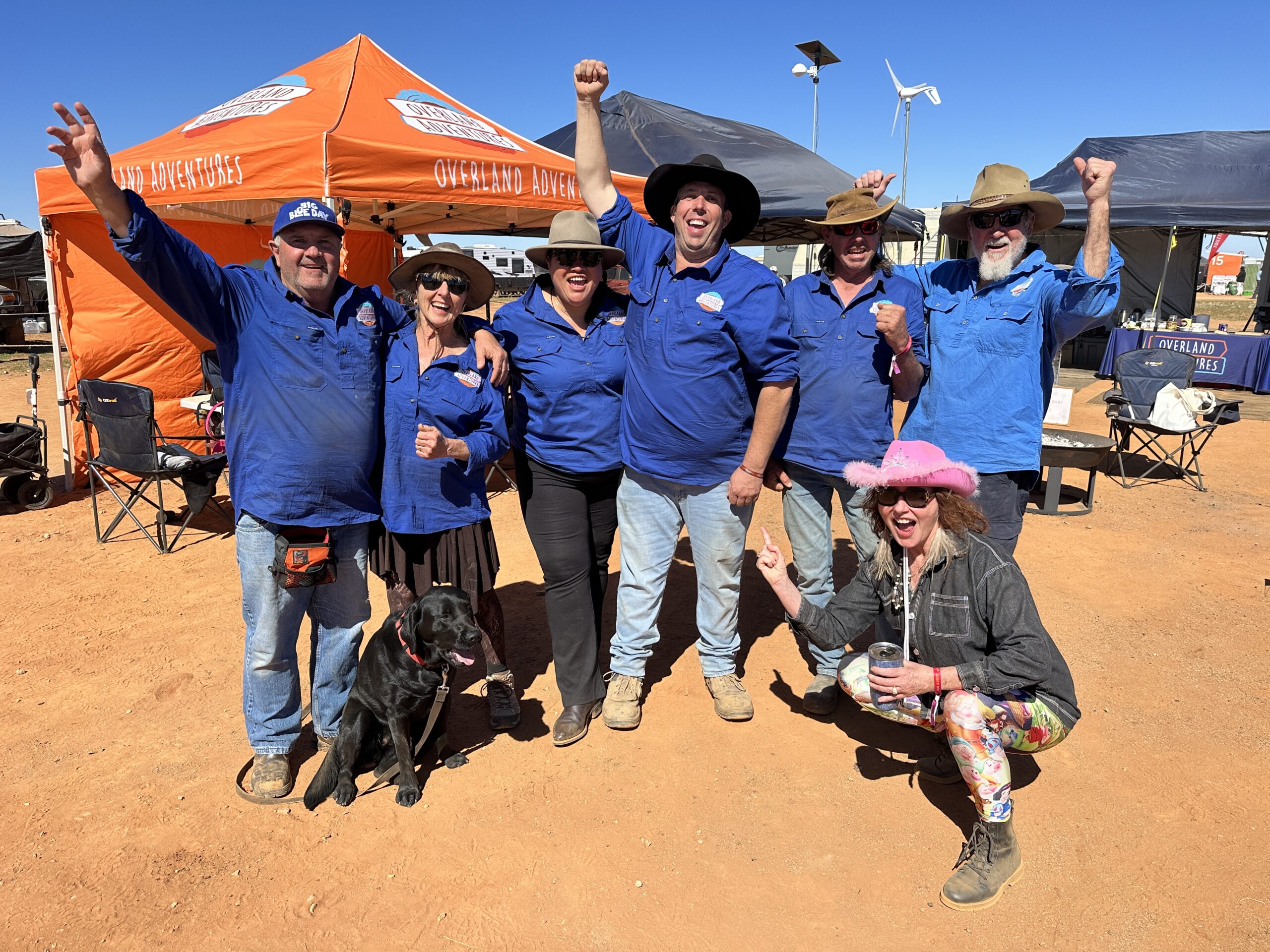 Overland Adventures team in blue shirts cheering at an outback event