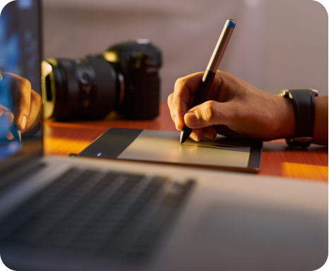 Designer drawing on a tablet beside a camera