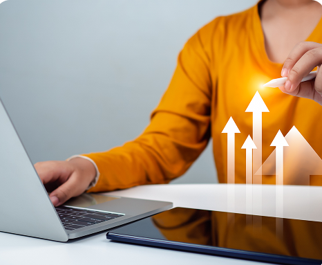 Person at a laptop with rising growth arrows